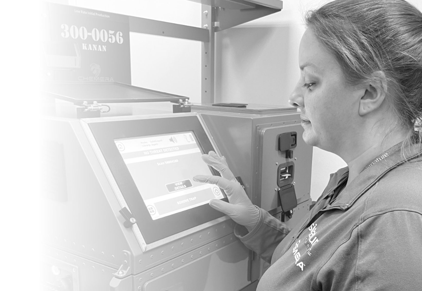 A white woman working on the screen of a large laboratory device