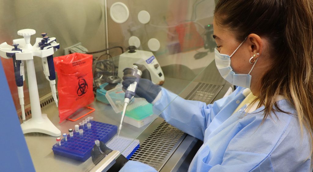 Female analyst using pipette to take samples